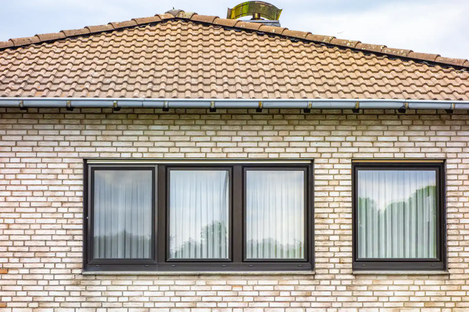 Energirigtige vinduer i en moderne bolig med sort ramme og reflekterende glas.